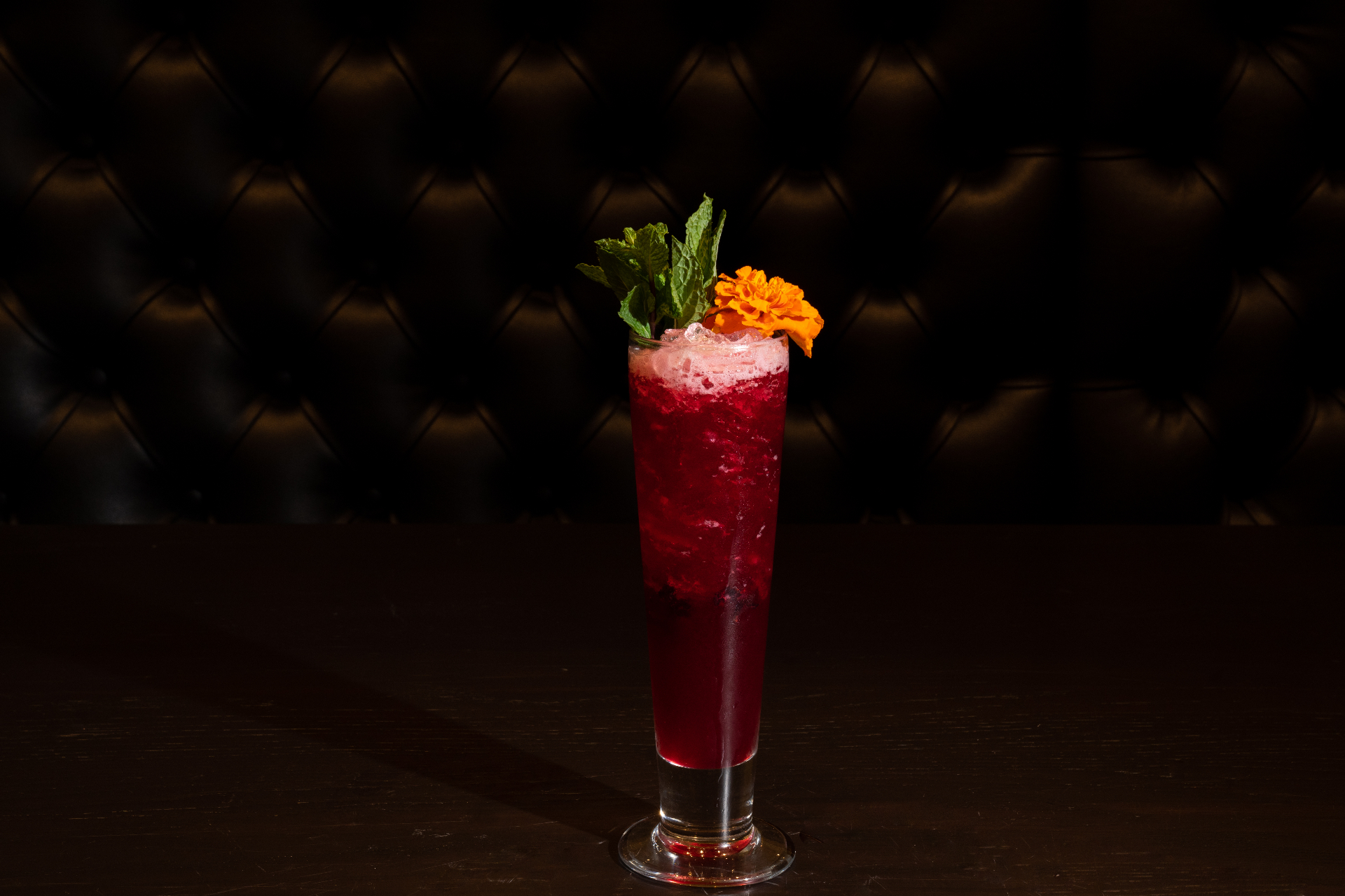 Berry cocktail with mint and marigold garnish